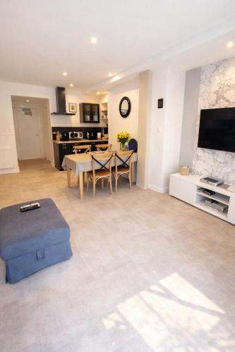 a large living room with a table and a tv at Le Lavoir de Loches in Loches