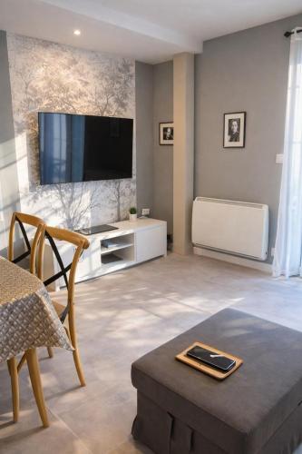 a living room with a flat screen tv on a wall at Le Lavoir de Loches in Loches