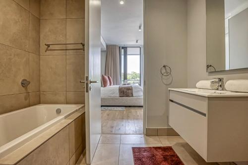 a bathroom with a tub and a sink and a bath tub at Caica Executives at Ellipse 4108 in Midrand