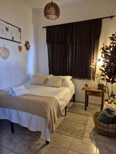 a bedroom with a large bed with a window at Mini Casa Tiradentes 2 in Tiradentes