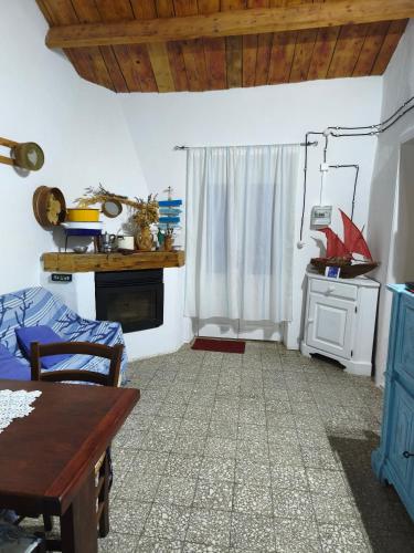 a room with a bed and a table and a window at Sa Domitta di Suiles in Olbia