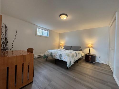 a bedroom with a bed and a dresser and a window at Beautiful Waterfront Apartment Quispamsis, NB in Catons Island