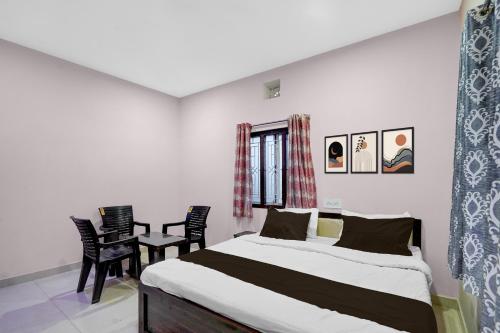 a bedroom with a bed and a table and chairs at Hotel O Candel Light Inn in Bhubaneshwar