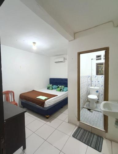 a bedroom with a bed and a toilet and a sink at PTS Homestay Syariah in Bandung