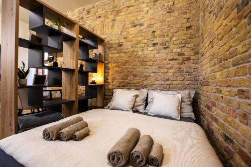 a bedroom with a large bed with a brick wall at Residence 1892 - Apartment 3 in Bratislava