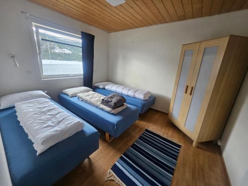 a small room with two beds and a window at HOL Familie Hous in Hol
