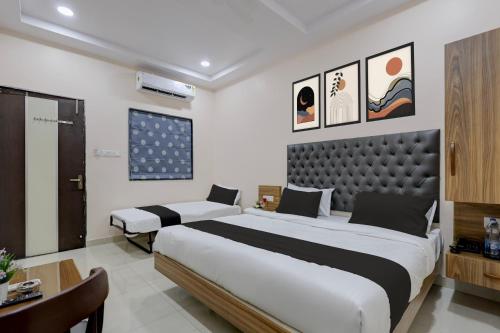 a bedroom with a large bed and a desk at Super HOTEL O MATRI CROWN in Raipur