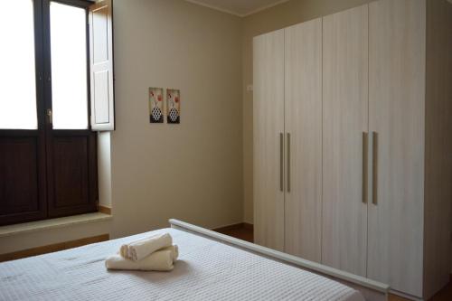 a bedroom with a white bed and a large wardrobe at La casa di Bice alloggio 1 in Cassibile
