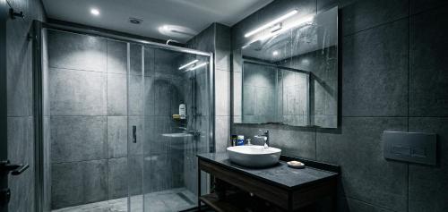 a bathroom with a sink and a shower at Kule Rezidance Hotel in Seyhan