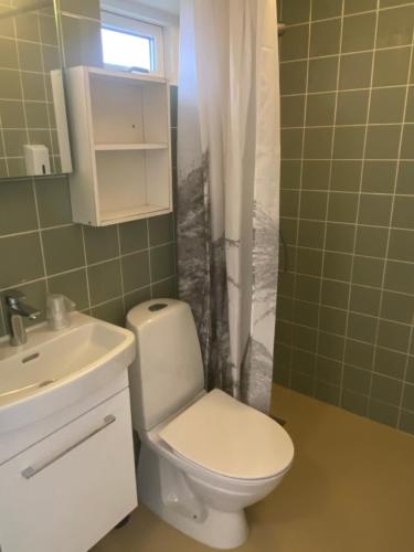 a bathroom with a white toilet and a sink at Hotel Villum in Sandvig