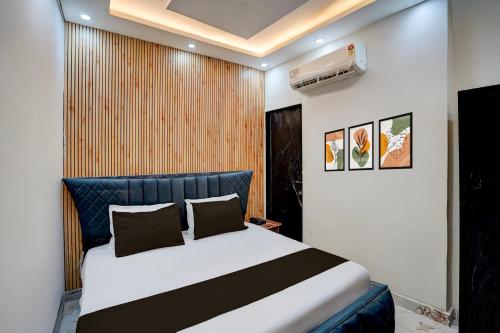 a bedroom with a large bed with a blue headboard at Hotel O J K Galaxy Hotel in Juhi Bari