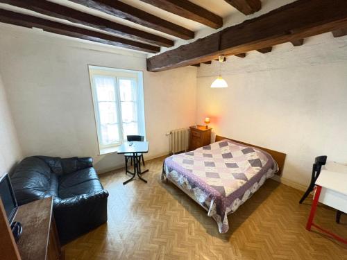 a bedroom with a bed and a couch and a window at hotel de la bonnaventure in Mazangé