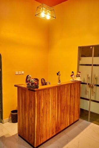 a bathroom with a wooden counter and a yellow wall at Boripe Hotel And Suites, Oluponna, Osun State in Olupona