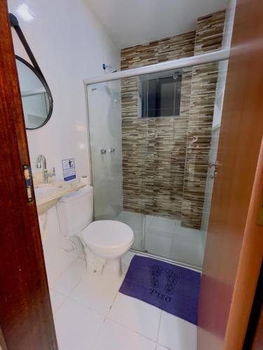 a bathroom with a toilet and a glass shower at Berenice Concept Residence - By Temporada Expert in Feira de Santana