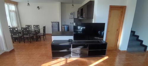 a living room with a flat screen tv on a black entertainment center at Peaceful huts in Manāli