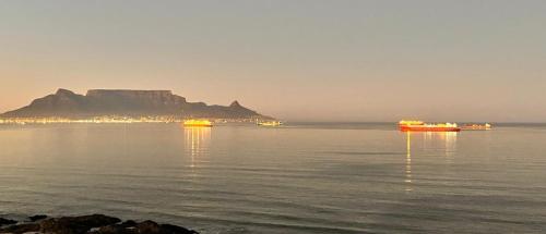 a large body of water with a mountain in the background at Atlantic Canvas - Mountain and Sea in Cape Town