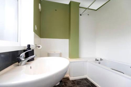 a bathroom with a white tub and a sink at 4BR Home with Parking Ideal for Contractors in Durham