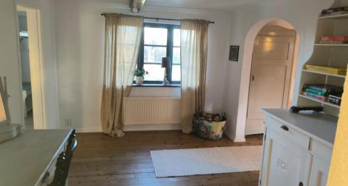 a room with a kitchen with a window and a table at Lilla lugnet in Ystad