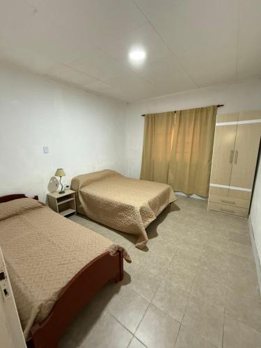 a bedroom with two beds and a tiled floor at La Casa de Alicia in Chivilcoy