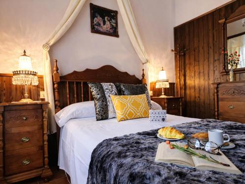 a bedroom with a bed with a tray of food on it at Medieval country house Señorío de Montero in Cenizate
