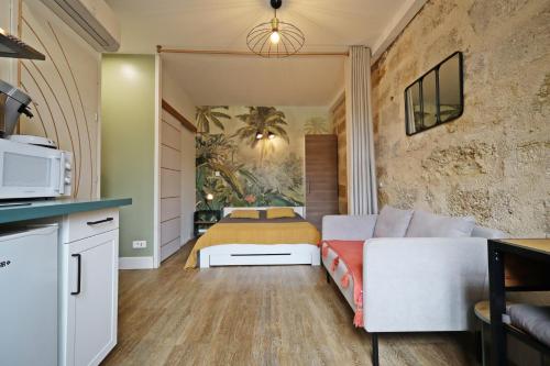 a living room with a couch and a bed at Au logis de Pézenas in Pézenas