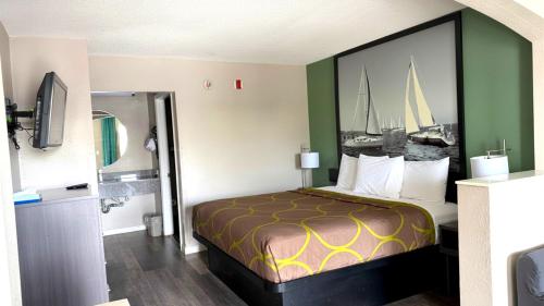 a hotel room with a bed with a picture on the wall at Super 8 by Wyndham Marianna I-10 in Marianna