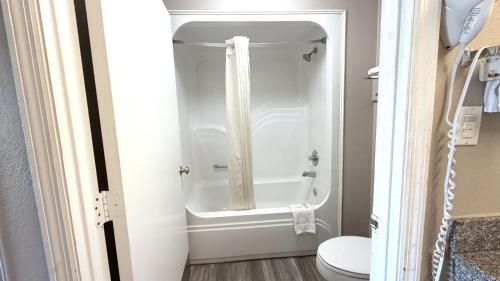 a bathroom with a shower with a toilet in it at Super 8 by Wyndham Marianna I-10 in Marianna