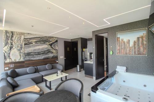 a room with a bath tub with a couch and chairs at Haven, A Design Hotel in Medellín