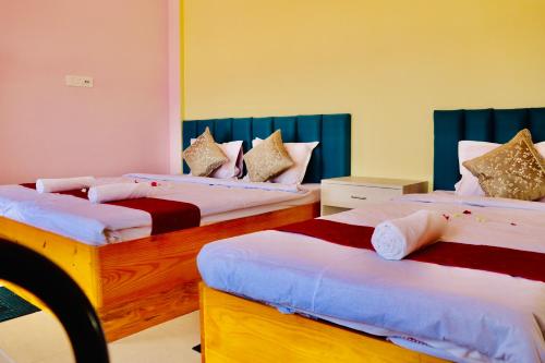 two beds in a room with two bedsskirts at Sky View Guest House in Shānti Niketan