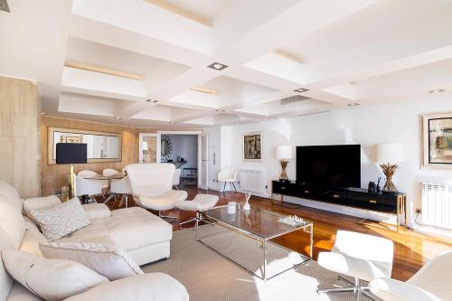 a living room with white furniture and a flat screen tv at Cascais Lux - New Apartment in Parede