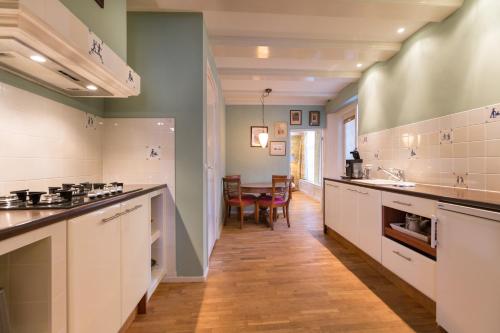 uma grande cozinha com balcões brancos e uma mesa em The Heritage - R.Q.C. em Haia