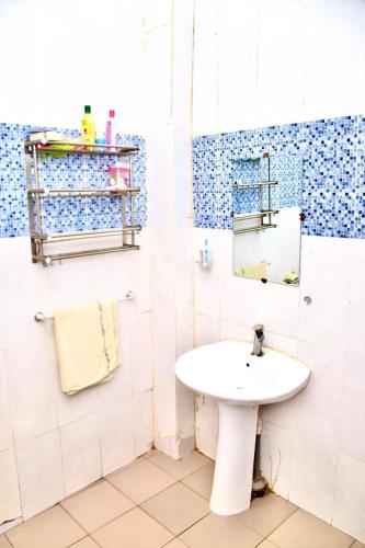 a white bathroom with a sink and a mirror at La belle vie in Rufisque