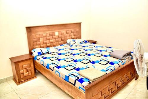 a bedroom with a bed with a blue and white comforter at La belle vie in Rufisque