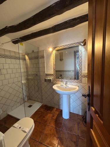 a bathroom with a sink and a toilet and a mirror at Casita El Granero in Iznatoraf