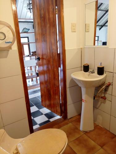 a bathroom with a sink and a toilet and a mirror at Amplio Apartamento en San Cristóbal con AC, Casa Oasis Galápagos in Puerto Baquerizo Moreno