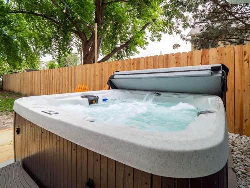 a large hot tub in a backyard with a fence at Hot Tub 5 Mins from Cedar Point Modern Updates in Sandusky
