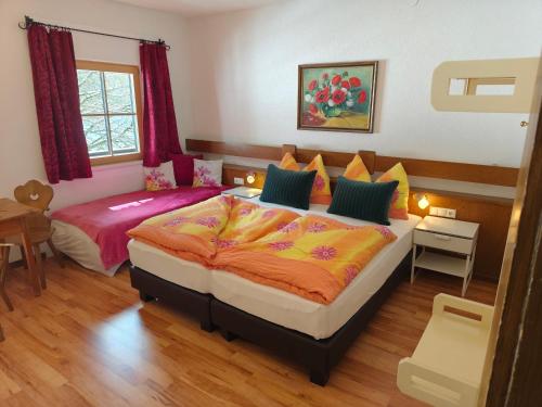 a bedroom with two beds and a table and a window at Berghotel Hinterduxerhof in Sparchen