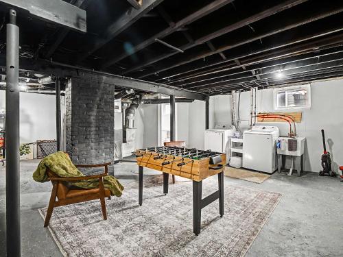 a room with a ping pong table and a chair at Newly Renovated and Designed Near Downtown in Cleveland