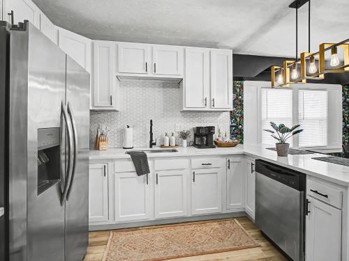 a kitchen with white cabinets and a stainless steel refrigerator at Newly Renovated and Designed Near Downtown in Cleveland