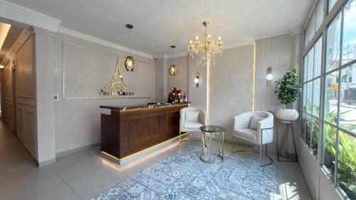 a lobby with a desk and two chairs and a chandelier at Hotel Paris Carré in Valledupar