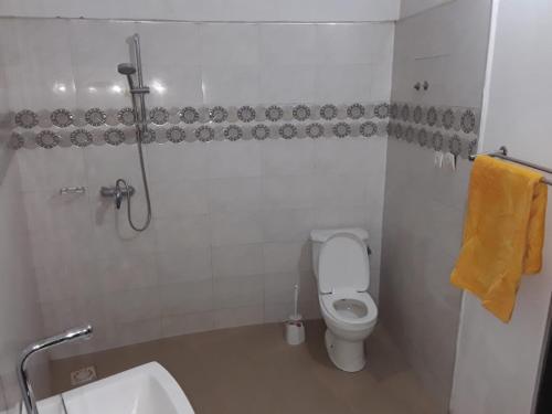 a bathroom with a white toilet and a sink at KEUR MAMY DOUSSOU à Ndangane campement in Ndangane