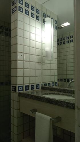 a bathroom with a sink and a mirror and a tub at Flat colado a praia de Boa Viagem in Recife