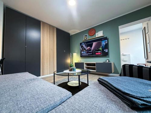 a bedroom with a bed and a tv on the wall at Apartman Mali Muk 2, self check in in Karlovac