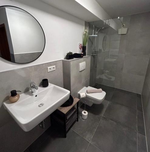 a bathroom with a sink and a toilet and a mirror at Apartments WK in Cologne