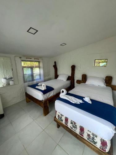 a bedroom with two beds with towels on them at Amplio Apartamento en San Cristóbal con AC, Casa Oasis Galápagos in Puerto Baquerizo Moreno