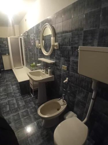 a bathroom with a sink and a toilet and a mirror at Al Sole Apartment in Locca