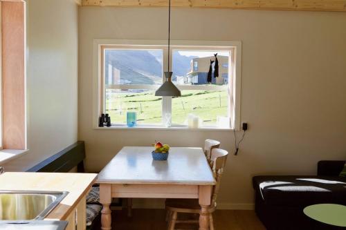 a living room with a table and a window at FjordNest Cabin in Hvannasund