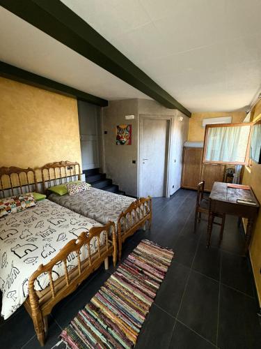 a bedroom with two beds and a table and chairs at Camera di Molly in Leivi
