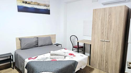 a bedroom with a bed and a wooden cabinet at Golden Tower Rooms - auto check-in in Gandía
