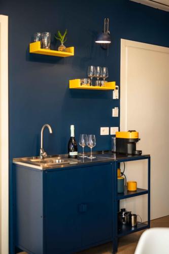 a kitchen with a sink and a blue wall at MR Suites Bergamo in Seriate